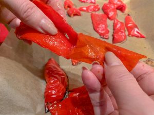 Peeling the skin off of the red peppers
